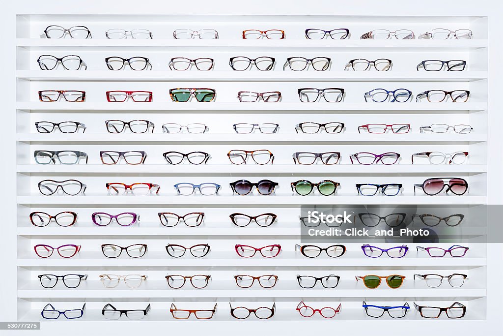 exhibitor of glasses exhibitor of glasses consisting of shelves of fashionable glasses shown on a wall at the optical shop Eyeglasses Stock Photo