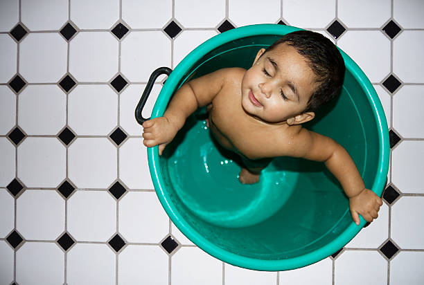 A child is closed her eyes while taking her photo during the bath