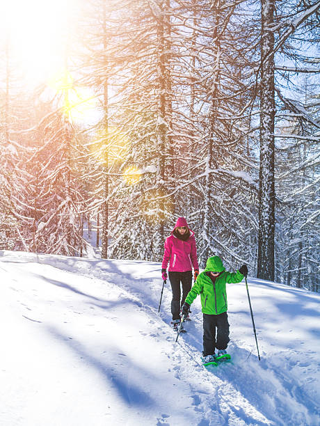 мать и сын на прогулку в снегоступах - snowshoeing snowshoe child winter стоковые фото и изображения