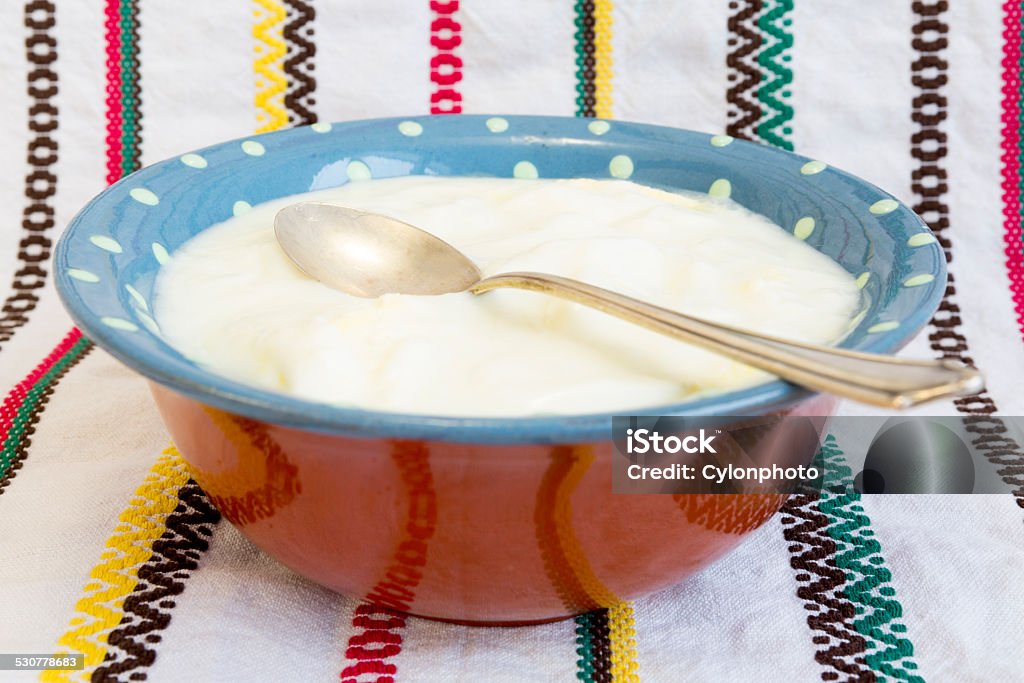 Homemade yoghurt spoon Homemade yoghurt and spoon on an embroidered cloth. Balance Stock Photo