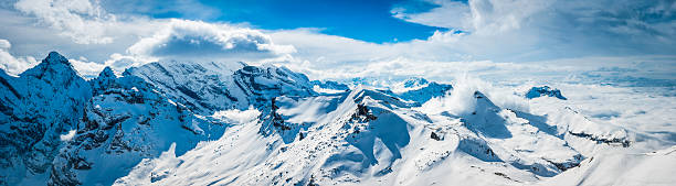 Photo of White mountains winter peaks panorama dramatic Alpine landscape above clouds