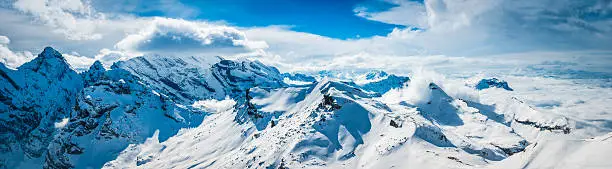 Sweeping panoramic vista across the crisp white glaciers, snow capped summits and dramatic rocky ridges of the Alps high in the idyllic mountain wilderness of the Bernese Oberland and Valais, Switzerland. ProPhoto RGB profile for maximum color fidelity and gamut.