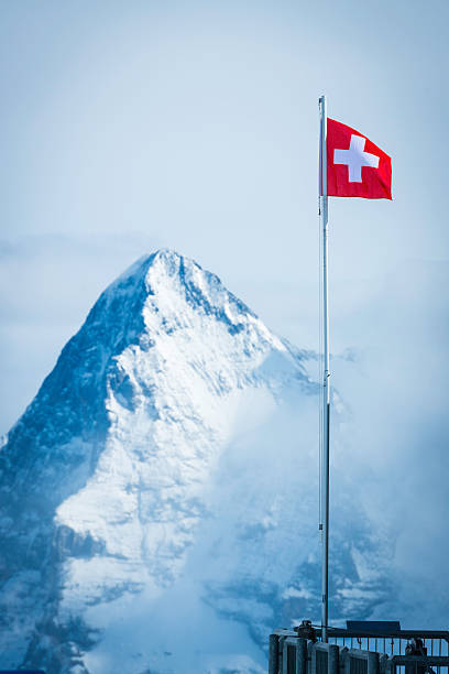 bandera suiza flying alta en alpes anteriormente eiger el pico de la montaña - eiger mountain swiss culture photography fotografías e imágenes de stock