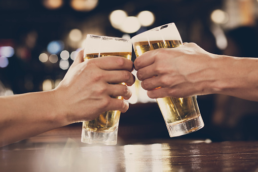 Hands of two men holding beer