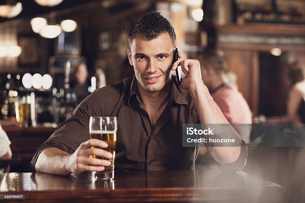 Young man with cell phone and beer Beer - Alcohol Stock Photo