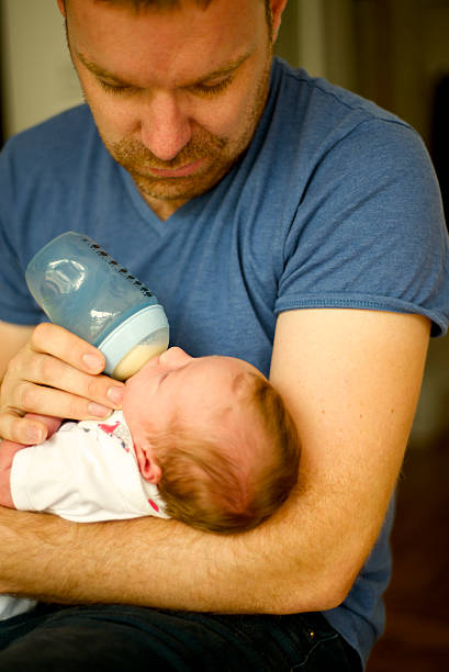 istock Caring father breastfeeds her daughter 530796163