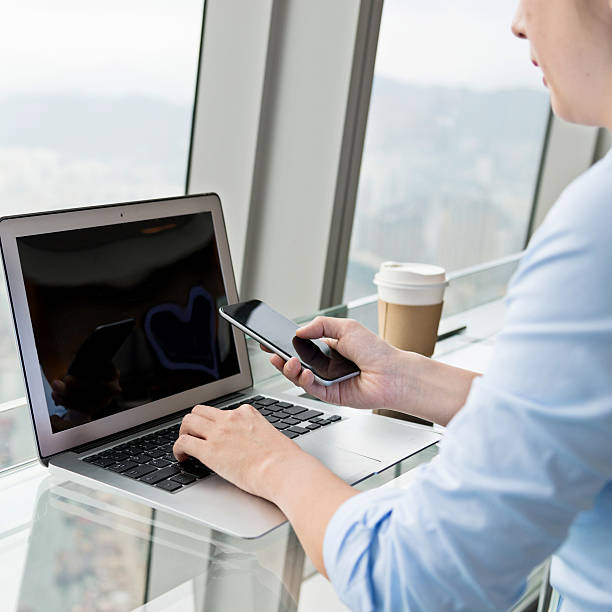 istock Businesswoman using phone and laptop 530804424