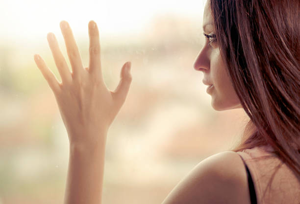 istock Young woman standing by a window 530805040