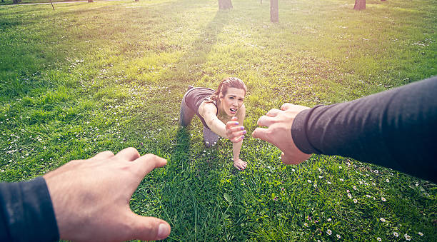 man helping girl in need girl reaching out hand seeking for help . fall down while running falling behind stock pictures, royalty-free photos & images