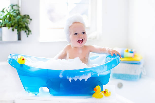 peu de prendre un bain de bébé - prendre un bain photos et images de collection