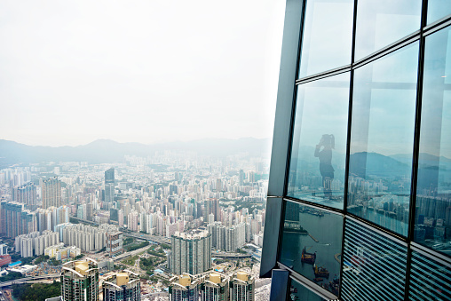 Businesswoman standing in a skyscraper building viewing over the city.