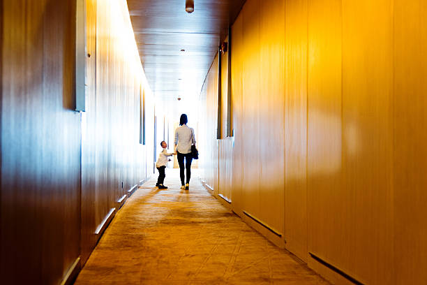 Rear view of mother and son walking into the light.
