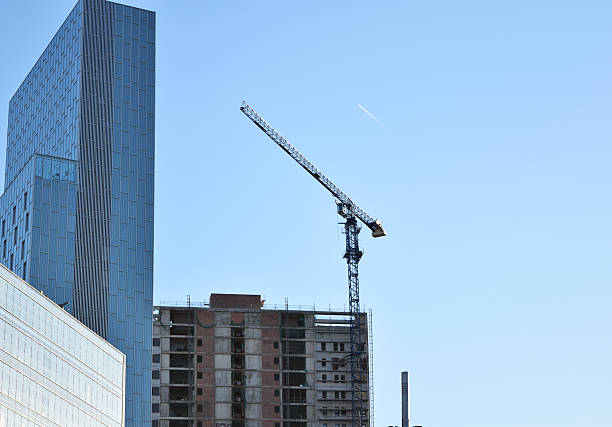 istock Building crane and building under construction against blue sky 530812958