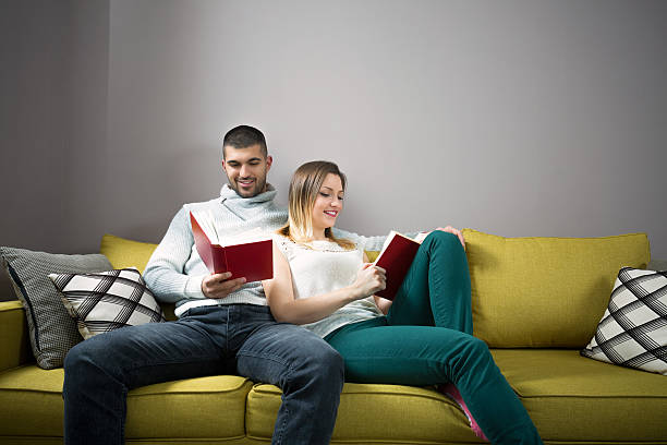 istock Young woman and man reading a book together. 530814552