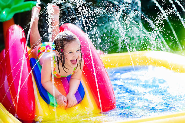 menina jogando no jardim piscina insuflável - swimming child swimwear little boys imagens e fotografias de stock