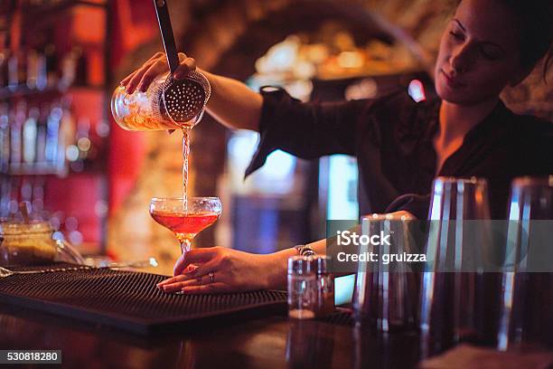 Young Female Bartender Pouring Cocktails In A Cocktail Bar Stock Photo - Download Image Now