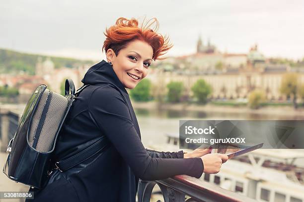 Female Tourist Looking At City Guide Stock Photo - Download Image Now - Adult, Adventure, Arranging