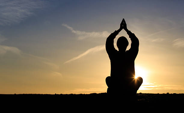 istock young man doing yoga at sunset sky 530822324