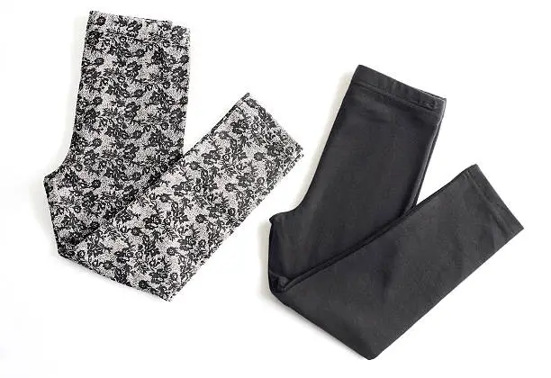 a set of folded yoga pants, black & floral design 