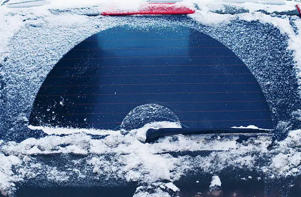 Photo of Winter frozen back car window, texture freezing ice glass backgr