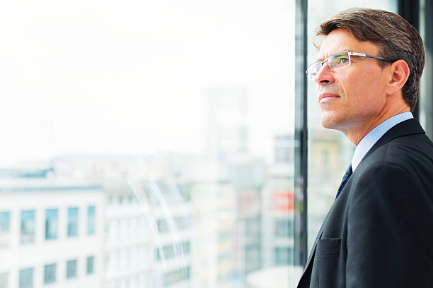 istock businessman standing by the window 530827807