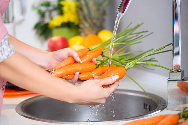 istock female hands washing carrots 530827903