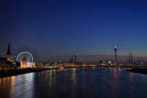 Dusseldorf cityscape along the rhine at night with a view on the old town, St. Lambertus church, Ferris Wheel, the Media Harbor, rhinetower and bridge