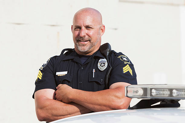 istock Police officer standing with arms crossed 530828347