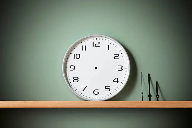 Blank clock face with hour, minute and second hands on the shelf.