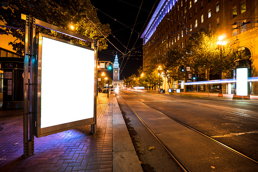 blank billboard on road with tramway in san francisco at night