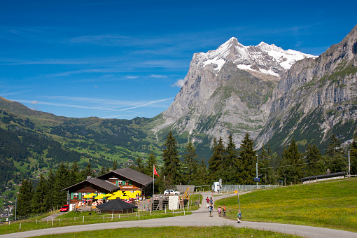Grindelwald, Switzerland - August 10, 2011: The historic Jungfraubahn station Brandegg with some tourists in front of the Wetterhorn in the Swiss Alps.