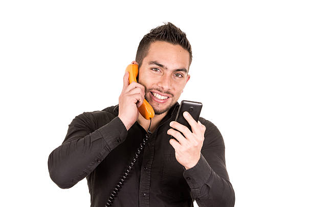 istock closeup shot of handsome man using corded telephone and cell 530840733
