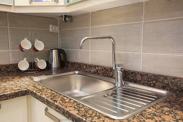 Sink and tap with kettle in apartment stock photo