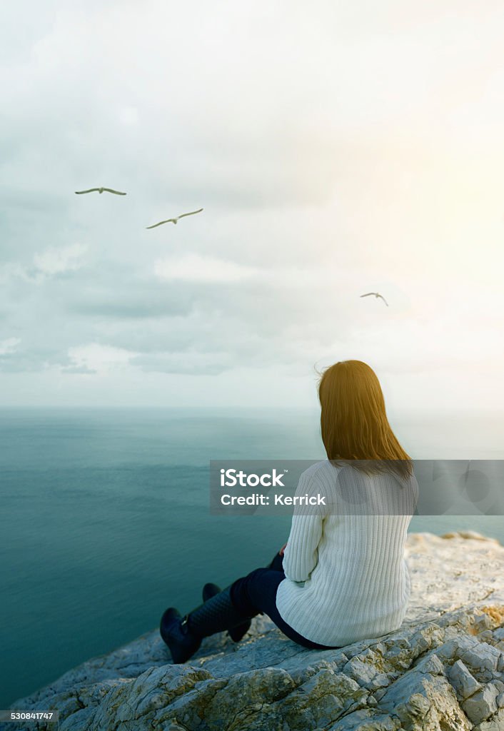 young woman dreaming on cliff young woman dreaming on cliff and looking to seagulls. 2015 Stock Photo