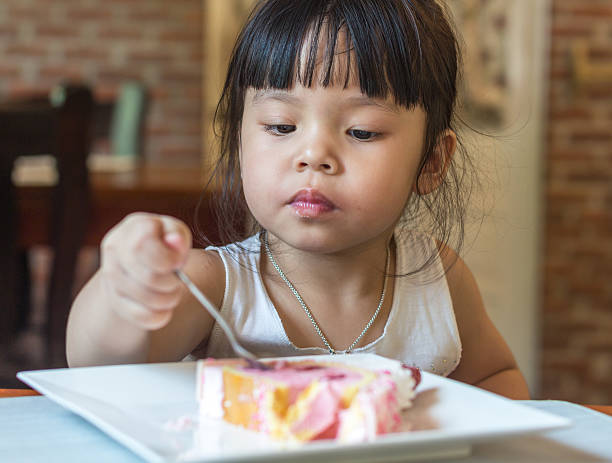 istock Children girl eating cake 530850339