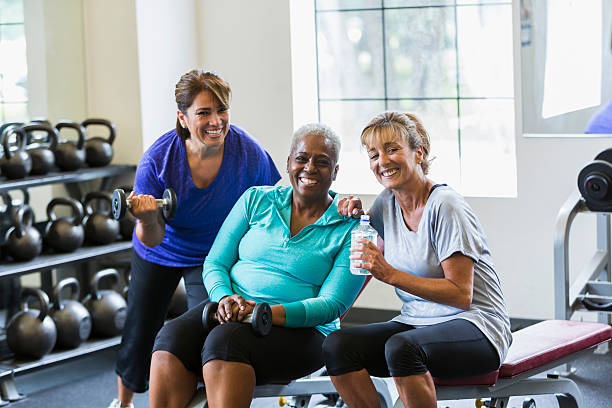 multiracial 熟年女性のグループでのフィットネスセンター - gym women inside of exercising ストックフォトと画像