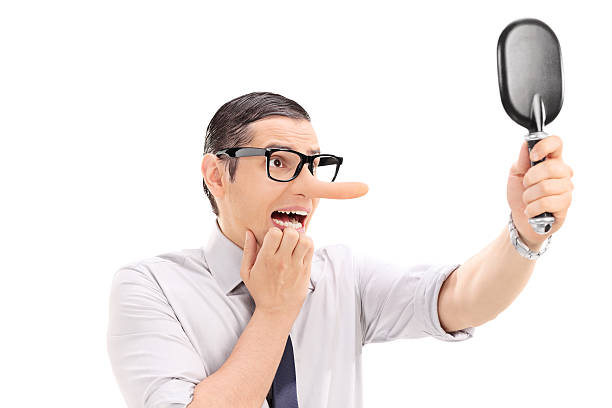 istock Scared man with long nose looking in a mirror 530854783