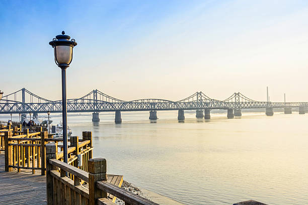 Yalu River Bridge and Yalu River Scenic Areas at morning. In the distance is North Korea. Located in Dandong City, Liaoning province, China.