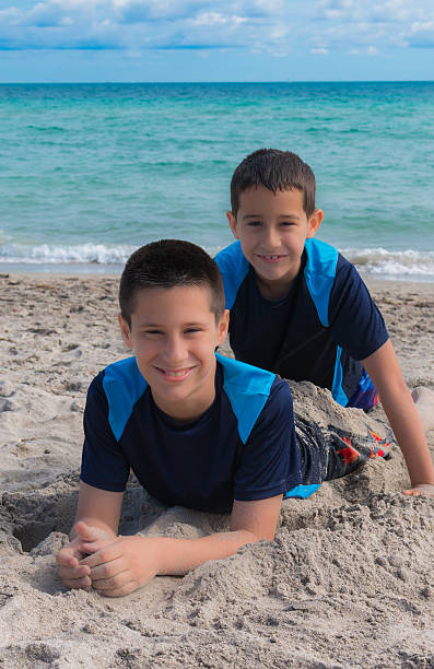 hispanic brothers playing at the beach