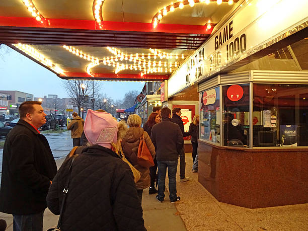 Good Day for the Movies Washington DC, USA-January 3, 2015:  These people are waiting in line to buy tickets at the Uptown Theatre in Cleveland Park in Northwest Washington DC.  The movie they are buying tickets for is called The Imitation Game and is about Alan Turing along with fellow codebreakers and their efforts to break the German Enigma code during WWII.  The ability to decipher an enemy's code can shorten a war. box office photos stock pictures, royalty-free photos & images