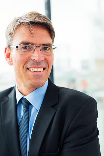 istock businessman standing by the window 530862923