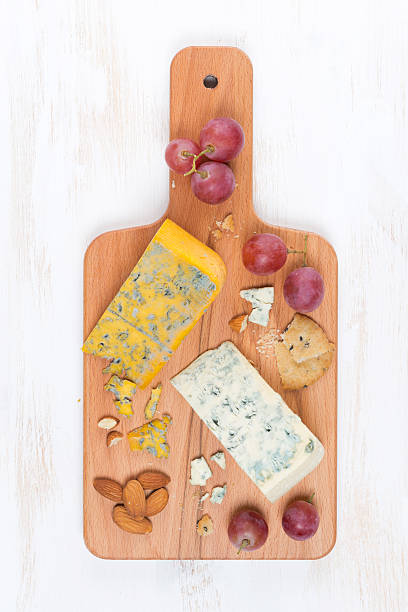 istock assorted soft cheeses, grapes, nuts on a wooden cutting board 530864469