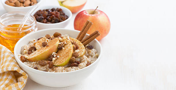 istock oatmeal with apples, raisins, cinnamon and ingredients on white 530864557