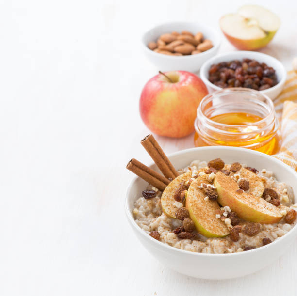 istock oatmeal with apples, raisins, cinnamon and ingredients on white 530864653