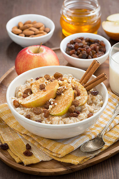 istock oatmeal with apples, raisins, cinnamon and ingredients, vertical 530864669