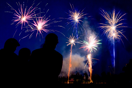 A silhouette of a family watching fireworks