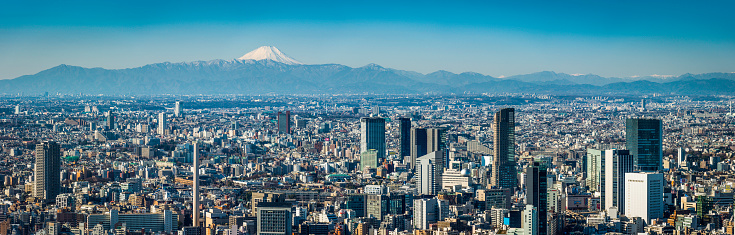 The iconic snow capped cone of Mt. Fuji overlooking the crowded cityscape and skyscrapers of downtown Tokyo. ProPhoto RGB profile for maximum color fidelity and gamut.