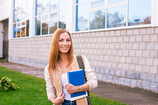 istock Student standing on building background and smiling 530876037