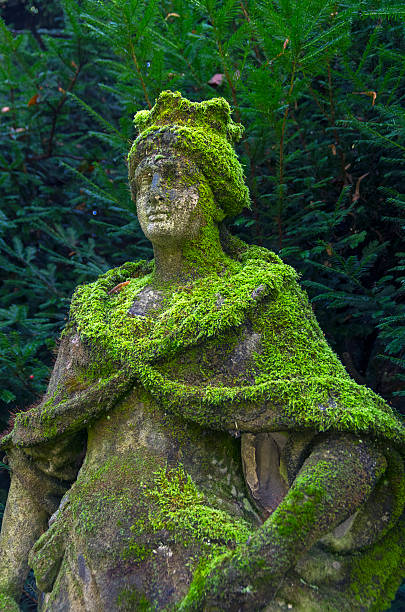 Old, dilapidated and moss-covered statue of Queen in Italian park.
