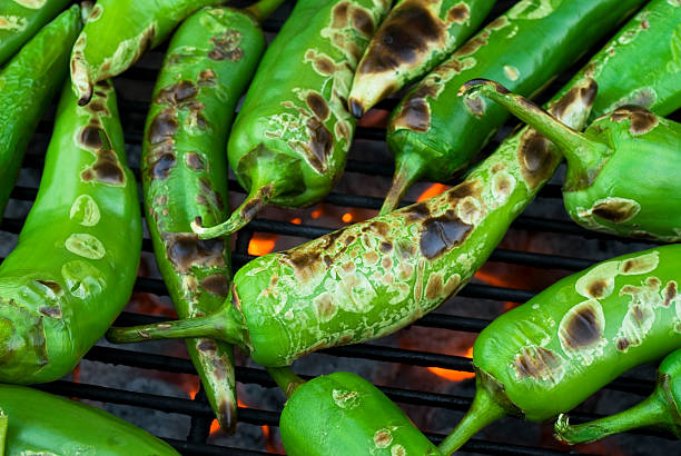 anaheim chilis roasting and blistered Fresh anaheim chili peppers being roasted over a charcoal grill anaheim pepper photos stock pictures, royalty-free photos & images
